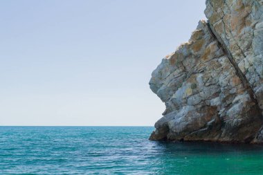 Yazın güneşli bir günde kumsalda dağlar ve kayalar