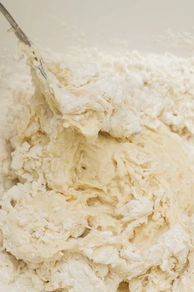 Готовить тесто в белой пластиковой миске дома — стоковое фото