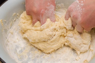 Cooking dough in a white plastic bowl at home