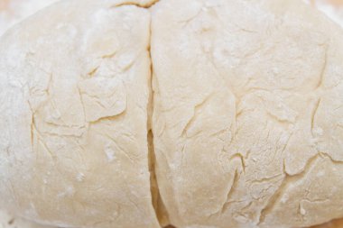 Prepared kneaded dough on a wooden table at home