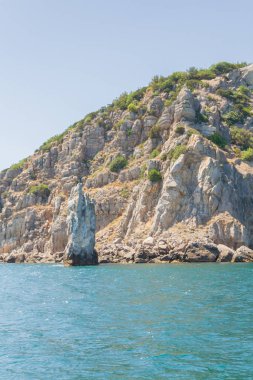 Yazın güneşli bir günde kumsalda dağlar ve kayalar