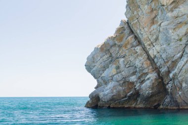 Yazın güneşli bir günde kumsalda dağlar ve kayalar
