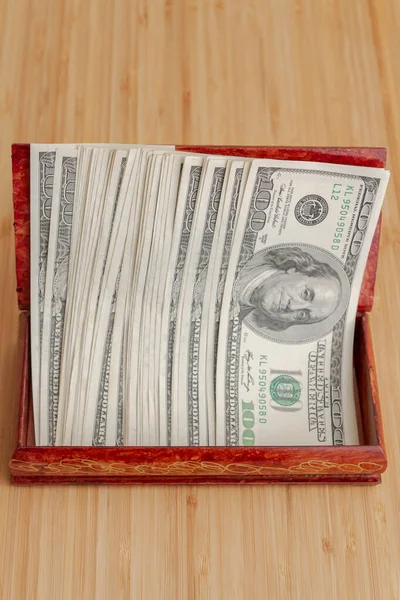 American hundred dollar bills in large quantities in a wooden box