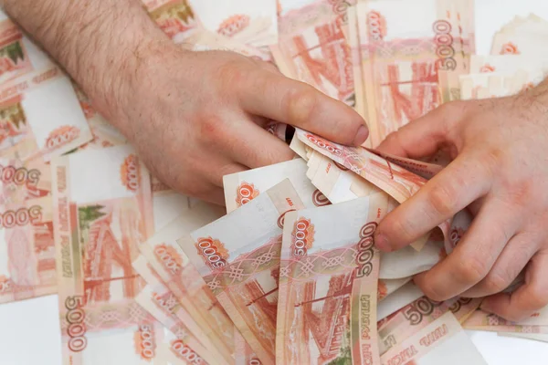 Men\'s hands hold a large amount of money with Russian banknotes of five thousand rubles