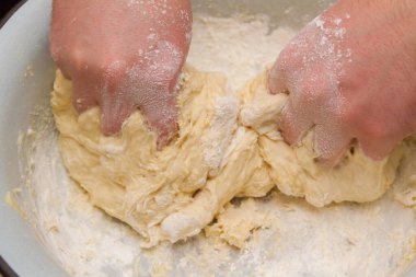 Cooking dough in a white plastic bowl at home