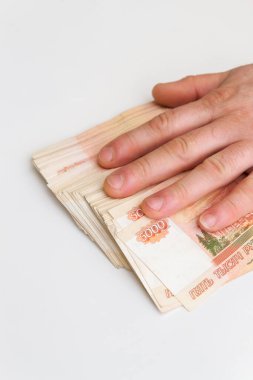 Bir adamın eli beş bin rublelik banknotları sayar ve taşır.