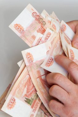 Beş bin rublelik Rus banknotlarıyla erkeklerin elinde büyük miktarda para var.