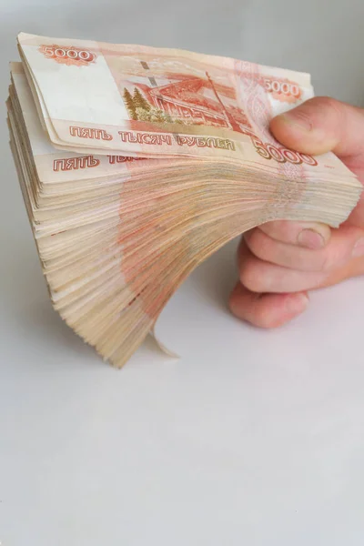 男人的手拿着一大把钞票 每包五千卢布 — 图库照片