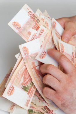 Beş bin rublelik Rus banknotlarıyla erkeklerin elinde büyük miktarda para var.