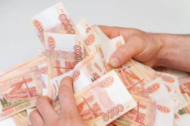 Beş bin rublelik Rus banknotlarıyla erkeklerin elinde büyük miktarda para var.