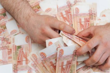 Beş bin rublelik Rus banknotlarıyla erkeklerin elinde büyük miktarda para var.