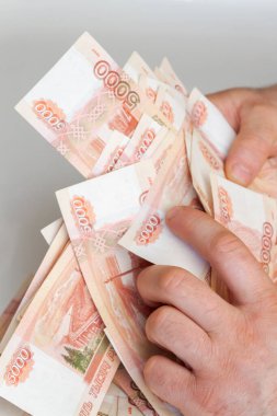 Beş bin rublelik Rus banknotlarıyla erkeklerin elinde büyük miktarda para var.