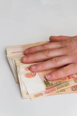Bir adamın eli beş bin rublelik banknotları sayar ve taşır.
