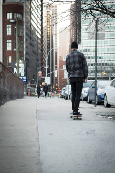Volledige terug figuur van een skateboarder cruisen naar beneden stad straat bef — Stockfoto