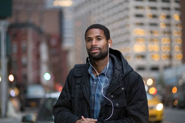 Portrait of African American man listening to music in the city — Stock Photo, Image