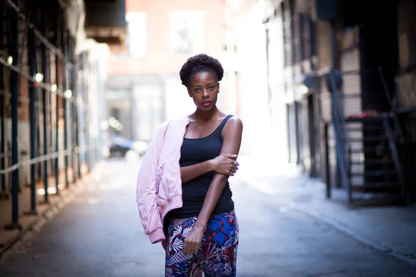 Portrait of young black woman on city street