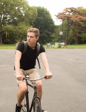 Modern genç üniversite öğrenci binmek bisiklet park