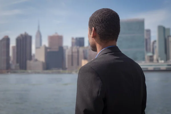 Back view of African American male professional in suits standin