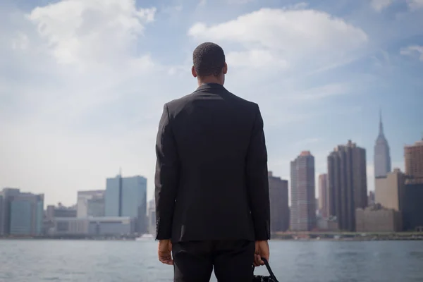 Back view of African American male professional in suits standin