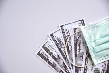 Tıbbi maske ve dolar parası, dünya koronavirüs salgını ve ekonomik kayıplar konsepti. Üst görünüm