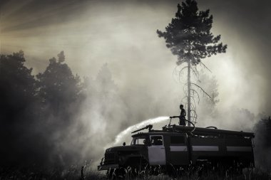 itfaiyeci ve gün batımında orman yangını