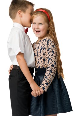 Çocuk bir sır kızın kulağına fısıldar.