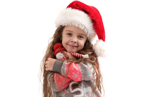 Little girl in a sweater holding a Christmas toy — Stock Photo, Image