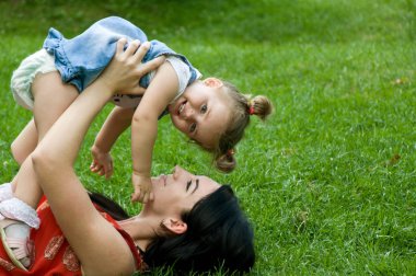 Anne ve kızı çimenlerin üzerinde eğleniyor