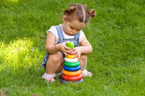 Κοριτσάκι παίζει με μια κατασκευή στη φύση. — Φωτογραφία Αρχείου