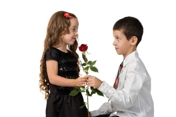 El niño le da una rosa roja a su novia. relación entre — Foto de Stock