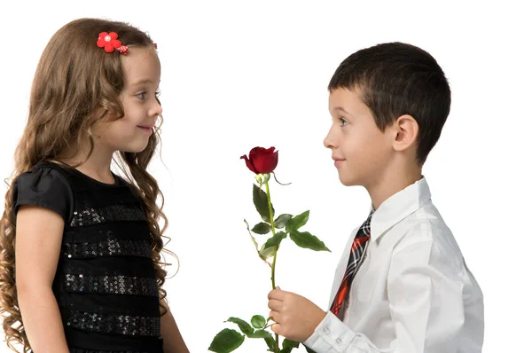 El niño le da una rosa roja a su novia. relación entre — Foto de Stock