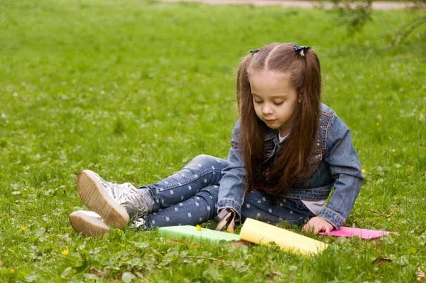En flicka en bok med ett förstoringsglas. Smarta lilla p — Stockfoto