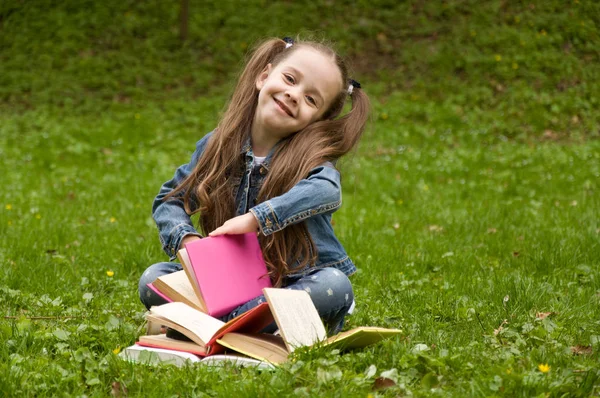 작은 여 학생 자연에서 책을 읽고 있다. 스마트 작은 pupi — 스톡 사진