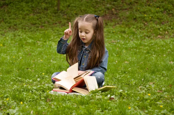 Smart little pupil is reading book — Stock Photo, Image