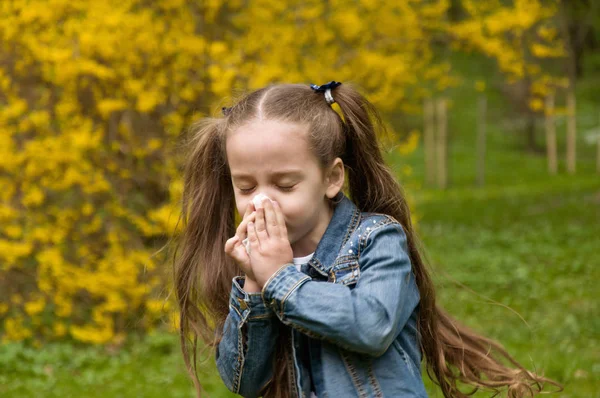 Flickan har en rinnande näsa. blommor pollenallergi. Flickan är en — Stockfoto