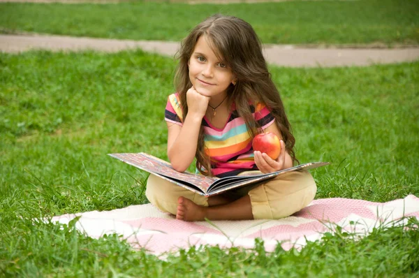 Lilla skolan barnen läsa en bok i naturen. Smart liten elev — Stockfoto