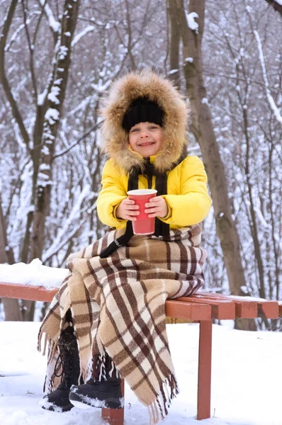 Kleines Mädchen im Winter auf der Straße und trinkt heißen Tee. — Stockfoto