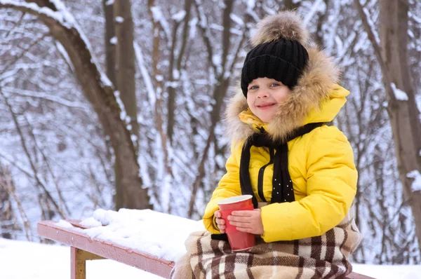 Маленькая девочка зимой на улице пьет горячий чай . — стоковое фото