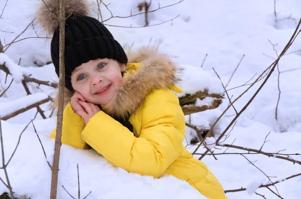 Kleines Mädchen spielt im Winter im Schnee. — Stockfoto