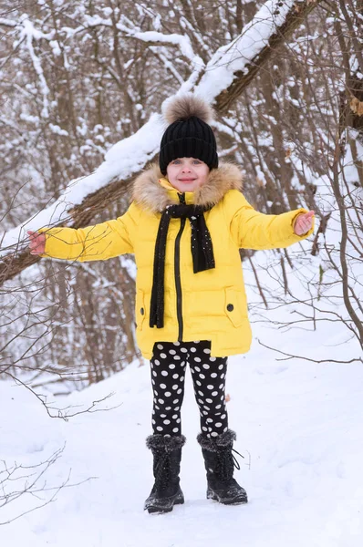 Kleines Mädchen spielt im Winter im Schnee. — Stockfoto