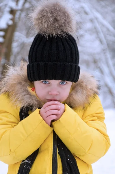 Kleines Mädchen spielt im Winter im Schnee. — Stockfoto