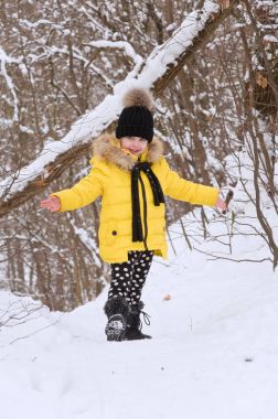 Kışın karda oynarken küçük kız.