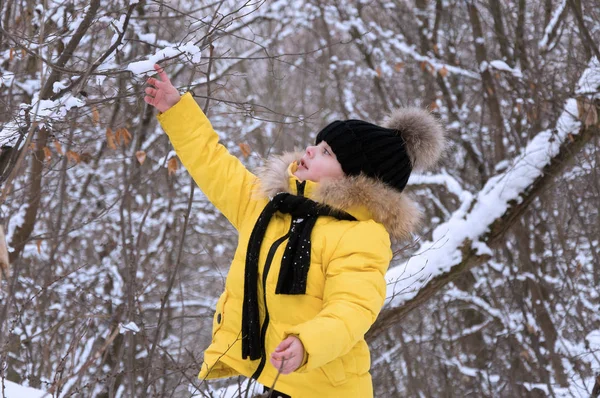 小さな女の子が冬の雪の中で遊んで. — ストック写真