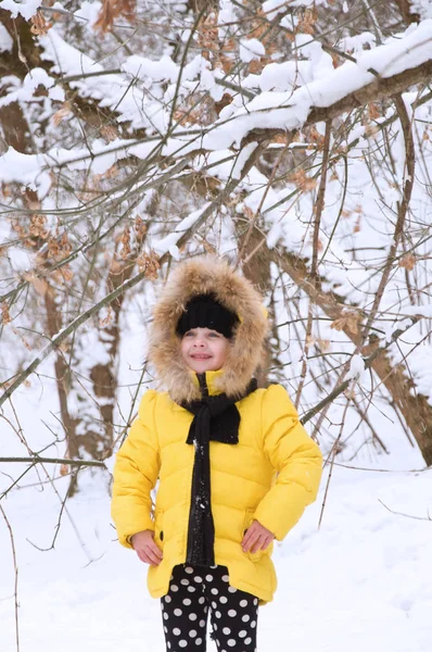 Kleines Mädchen spielt im Winter im Schnee. — Stockfoto