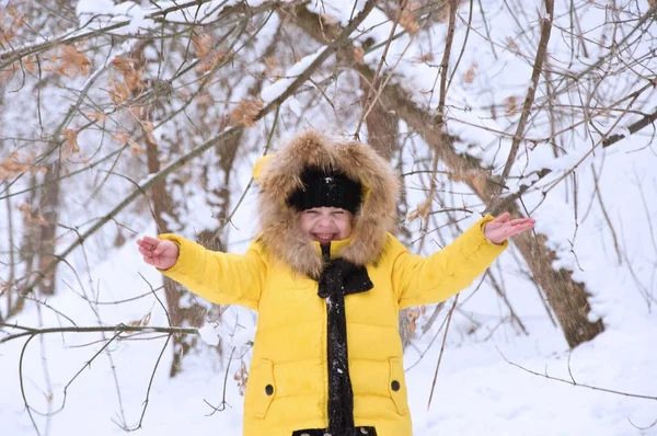 小さな女の子が冬の雪の中で遊んで. — ストック写真