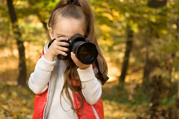 küçük kız bir kamera tutarak ve fotoğraf çekme. hobi.