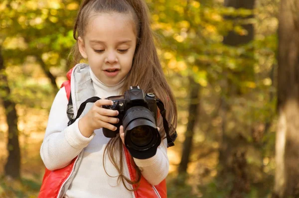 küçük kız bir kamera tutarak ve fotoğraf çekme. hobi.