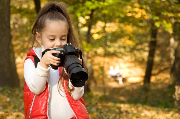 küçük kız bir kamera tutarak ve fotoğraf çekme. hobi.