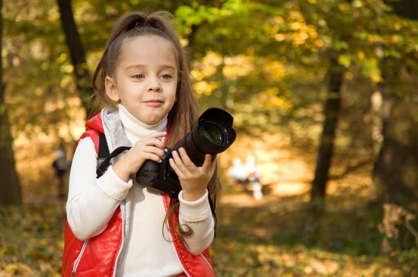 küçük kız bir kamera tutarak ve fotoğraf çekme. hobi.