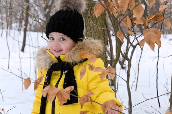 Kleines Mädchen spielt im Winter im Schnee. — Stockfoto